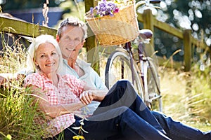 Middle Aged Couple Relaxing On Country Cycle Ride