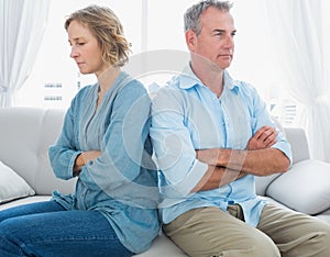 Middle aged couple sitting on the couch not speaking after a fig