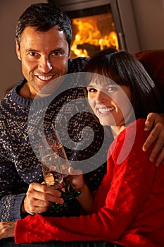 Middle Aged Couple Sitting Sofa By Cosy Log Fire
