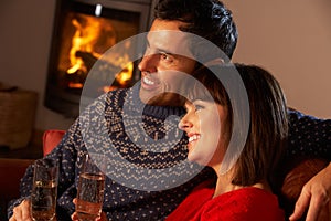 Middle Aged Couple Sitting Sofa By Cosy Log Fire