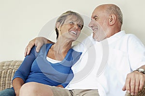 Middle Aged Couple Sitting On Wicker Couch