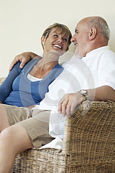 Middle Aged Couple Sitting On Wicker Couch