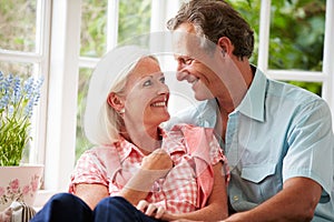 Middle Aged Couple Sitting On Window Seat Together