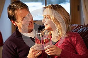 Middle Aged Couple On Sofa With Champagne