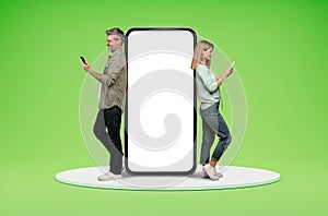 Middle aged couple standing by big phone with white screen