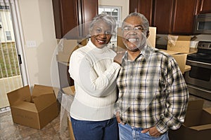 Middle-aged couple standing in kitchen with boxes.