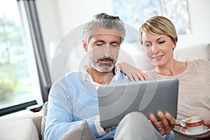 Middle-aged couple on tablet websurfing photo