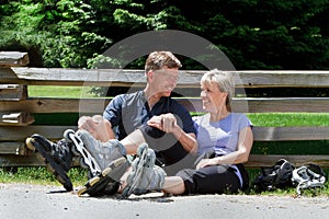 Middle-aged couple taking a break while out rollerblading.