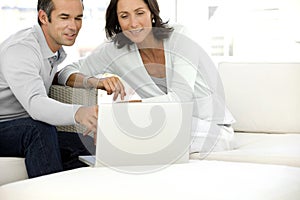 Middle-aged couple using laptop