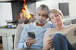 Middle-aged couple using smartphones