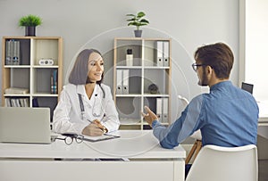 Middle aged doctor sitting at her desk and having a conversation with her patient