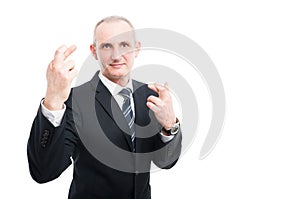 Middle aged elegant man making double fingers crossed gesture