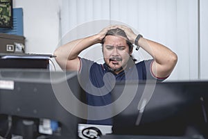 A middle aged employee overwhelmed by problems at the office. Computer shutting down, did not save document