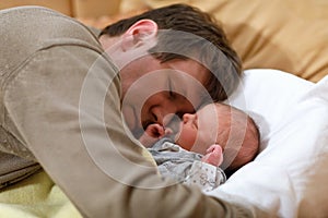 Middle aged father cuddling with his newborn baby daughter