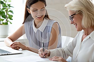 Middle-aged female employee sign contract at meeting