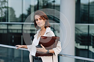 Middle-aged female with folder at business building