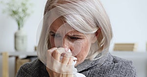 Middle aged female retiree caught cold, sneezing.