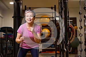 Middle aged focused woman wearing sportswear doing sport exercise in gym