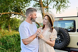 Middle-aged happy couple outdoors on a walk, man gives flowers to woman