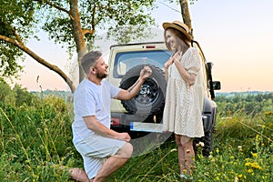 Middle-aged happy couple outdoors on a walk, man gives flowers to woman