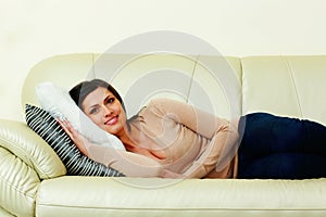 Middle-aged happy woman lying on the sofa