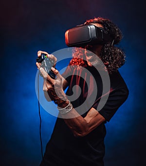 Middle aged hispanic male playing with virtual reality glasses and video game controller