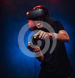 Middle aged hispanic male playing with virtual reality glasses and video game controller