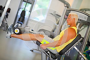 Middle-aged instructor does exercises on simulator photo