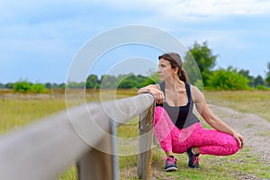 Middle aged jogger leaning on guard rail