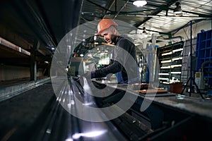 Middle-aged male is gluing spacer frames at a window factory