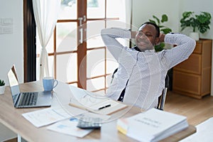 middle aged man American African business man holding computer laptop with hands up in winner is gesture, Happy to be