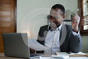 middle aged man American African business man holding computer laptop with hands up in winner is gesture, Happy to be