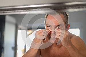 Middle aged man applying a nose tape
