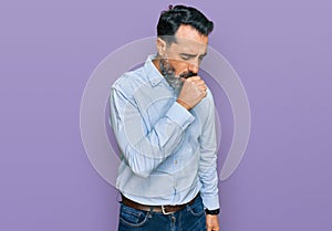 Middle aged man with beard wearing business shirt feeling unwell and coughing as symptom for cold or bronchitis