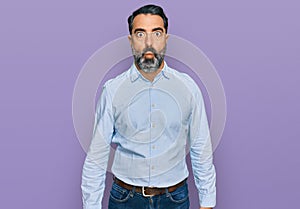 Middle aged man with beard wearing business shirt making fish face with lips, crazy and comical gesture