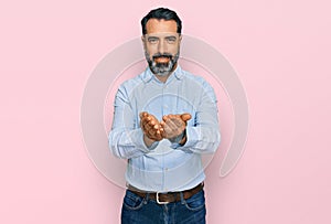 Middle aged man with beard wearing business shirt smiling with hands palms together receiving or giving gesture