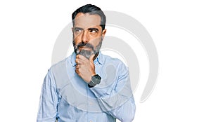 Middle aged man with beard wearing business shirt thinking worried about a question, concerned and nervous with hand on chin