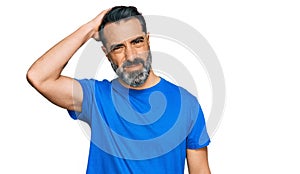 Middle aged man with beard wearing casual blue t shirt confuse and wonder about question