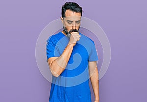Middle aged man with beard wearing casual blue t shirt feeling unwell and coughing as symptom for cold or bronchitis