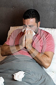 Middle-aged man in bed sick with flu symptoms