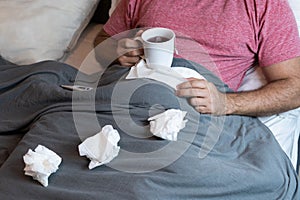 Middle-aged man in bed sick with flu symptoms