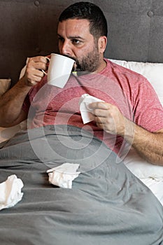 Middle-aged man in bed sick with flu symptoms