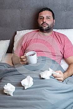 Middle-aged man in bed sick with flu symptoms