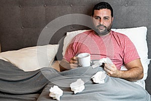 Middle-aged man in bed sick with flu symptoms