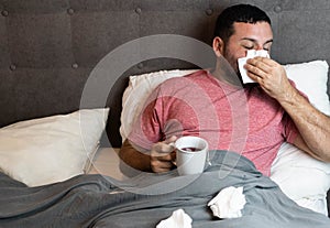 Middle-aged man in bed sick with flu symptoms