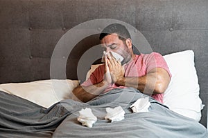 Middle-aged man in bed sick with flu symptoms