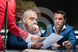 Middle-aged man calling his attorney during a difficult police interrogation
