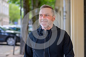 Middle-aged man chuckling to himself as he walks through town