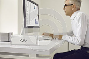 Middle-aged man cpa manager sits at a computer looking at traffic statistics.