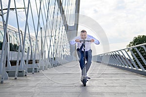 Middle-aged man crouching low as he speeds along on a scooter